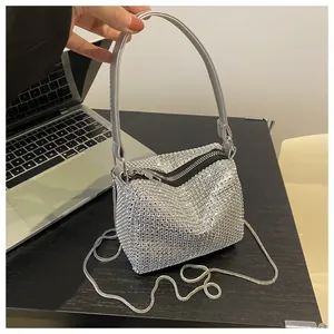 Close-up of sparkling silver rhinestones on luxury evening bag with metal chain strap