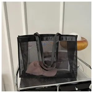 Detalle de bolso tote de malla negra que muestra gran capacidad y transparencia