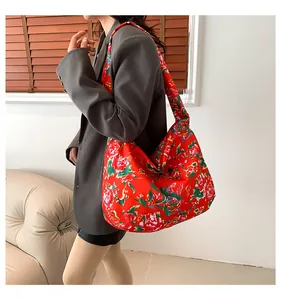 Detailed macro view of vibrant red floral canvas tote bag with traditional peony pattern