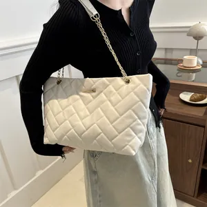 Chic white quilted tote bag with golden chain strap and large capacity shown on person