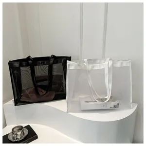 Detalle de los bolsos tote de malla blancos y negros con correas y tejido de nailon transpirable
