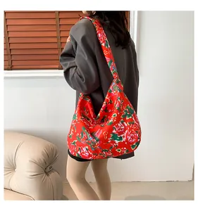 Detailed close-up of a large ethnic tote bag with red peony patterns and wide shoulder strap