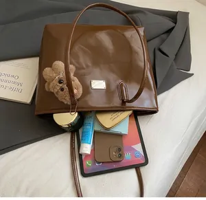 Primer plano del interior espacioso del bolso tote de cuero marrón oscuro con detalle plateado