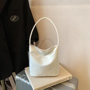 Minimalist beige shoulder bag with Past and Future embroidery in a lifestyle setting