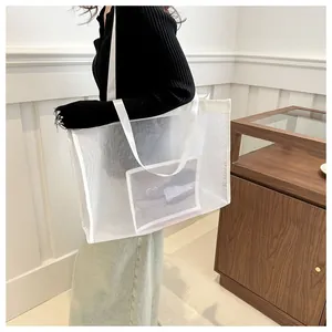 Detalle de bolso de malla blanca que muestra gran capacidad y textura de rejilla tejida