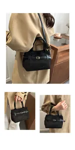 Vue triple d'un sac seau en daim noir avec boucle dorée et bandoulière amovible