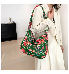 Close-up of ethnic tote bag featuring red peony and phoenix prints on dark green fabric