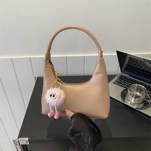 Borsa sottobraccio minimalista in pelle beige opaca con ciondolo in peluche rosa