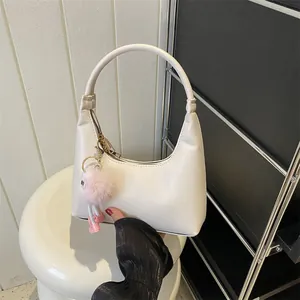 Borsa sottobraccio minimalista bianco crema con ciondolo in peluche rosa su supporto