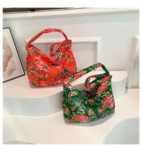 Detailed view of red and green folk style hobo bags with traditional dragon peony patterns