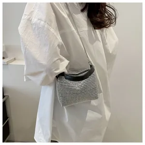 Close-up of sparkling rhinestone mini handbag with black handle and metal chain strap