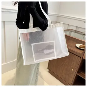 Detalle de bolso de malla blanca con estampado gráfico minimalista en un modelo