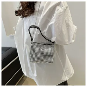 Close-up of sparkling silver rhinestone evening bag with elegant black leather handle