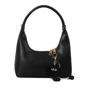 Elegante borsa hobo nera in ecopelle dal design minimalista con ciondolo di peluche