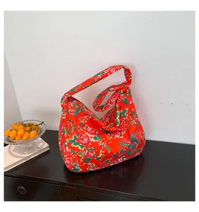 Close-up of red ethnic floral canvas hobo tote bag with traditional peony pattern