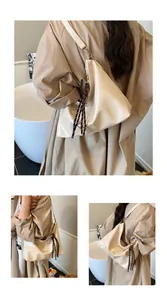Détails du sac hobo en cuir PU crème avec nœuds tressés et breloques métalliques chic