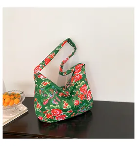 Detail of green floral canvas tote bag with traditional Chinese folk pattern on wood
