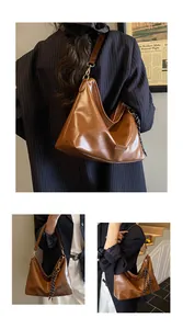 Vue détaillée du sac sous le bras marron rétro avec boucle dorée et foulard en soie