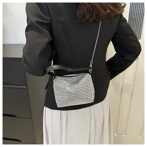 Silver rhinestone mini evening bag with black leather handle shown on model