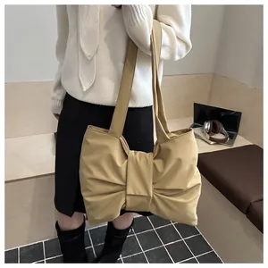 Detail van de kaki nylon hobo tas met een grote decoratieve strik en brede schouderband