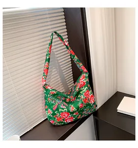 Detailed view of large green satin tote bag with traditional red peony floral patterns