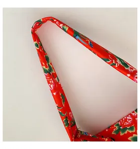 Close-up of ethnic tote bag with red floral pattern and golden metal zipper detail