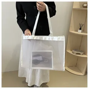 Detalle del bolso tote de malla blanca con parche de foto sostenido por una modelo moderna