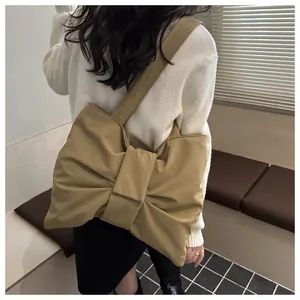 Detailansicht der khakifarbenen Schultertasche mit Schleife, getragen von Model
