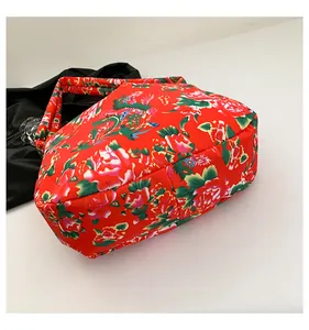 Detail of red floral tote bag with traditional peony pattern and dragon fabric texture