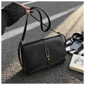Close-up of vintage black PU leather square bag with pleated texture and gold hardware