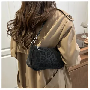 Detail of trendy leopard print underarm bag with silver hardware on a khaki trench coat