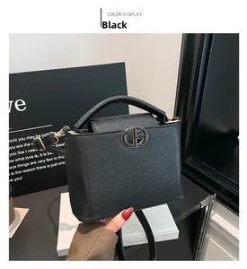 Dettaglio della pelle nera con trama litchi e chiusura in metallo dorato sulla borsa Kelly