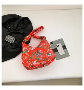 Detailed view of large ethnic red floral tote bag with dragon patterns and quilted texture