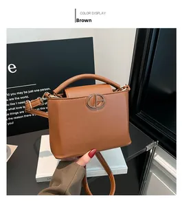 Dettaglio borsa marrone con fibbia in metallo dorato CD e trama in pelle martellata