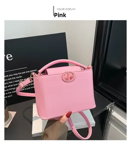 Dettaglio borsa in pelle rosa con fibbia circolare in metallo dorato lucido