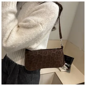 Close-up of trendy leopard print baguette bag with textured fabric and metal hardware