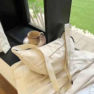 Minimalist beige nylon half-moon crossbody bag with wide strap for daily casual wear