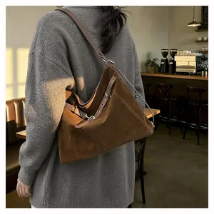 Detail view of large dark brown suede tote bag with vintage leather buckle strap decoration