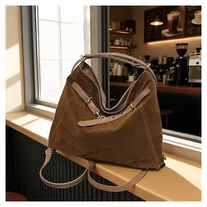 Detail of vintage brown tote bag with adjustable straps and silver hardware in a cafe