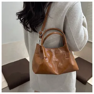 Caramel retro pleated handbag with round handles and detachable shoulder strap on model