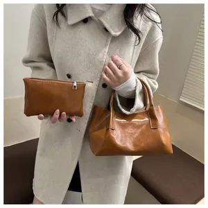 Detail of vintage brown tote bag set with matching pouch carried by a woman in beige coat