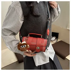 Detail of red Boston bag featuring silver studs, metal twist lock and floral wide strap