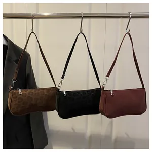 Detail view of stylish leopard print underarm bags with zipper closure and slim straps