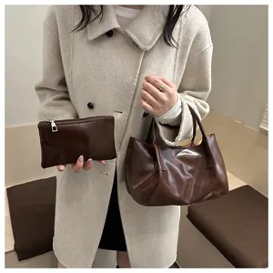 Detail of vintage brown pleated faux leather tote bag and matching small zipper pouch