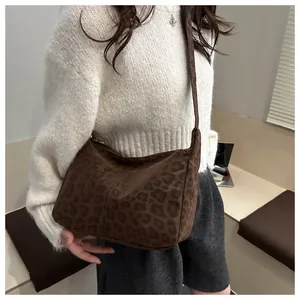 Detail of leopard print shoulder bag in brown suede with metal zipper and adjustable strap