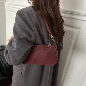 Deep red leopard texture hobo bag worn with a gray suit for a chic minimalist look
