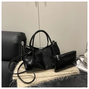 Detail of vintage pleated handbag in black faux leather with matching zipper pouch and strap