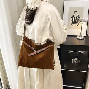 Retro brown suede tote bag with decorative stitching worn with a beige trench coat