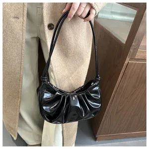 Détail du sac hobo noir plissé brillant avec texture en similicuir et fine bandoulière
