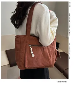 Détail du sac cabas en velours côtelé marron avec tirette tressée et poche latérale utile